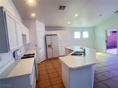 Kitchen with visible vents, an island with sink, a