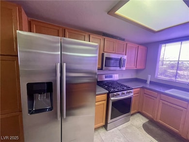 Kitchen with light tile patterned flooring, dark c