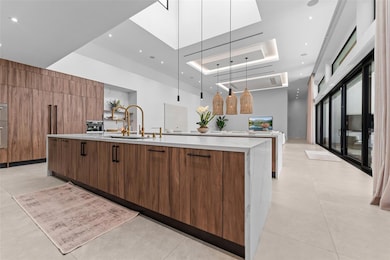 Natural light beaming from above kitchen island window with pendant lighting and led lights throughout the kitchen for night time lights. Custom kitchen cabinets are imported from Italian brand Cucina Lube.