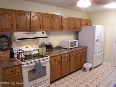 Eat In Kitchen is spacious w/ceramic tile flooring, new ceiling fan/light fixture, 3 other new ceiling lights, lots of cabinets/counter/drawer space, eat-in area for table and chairs, door access to Family Room, rear door to exterior home, newer counter tops and a viewing window into the Family Room.