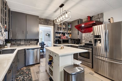 Kitchen featuring appliances with stainless steel finishes, light countertops, tasteful backsplash, and open shelves
