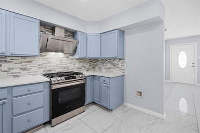 Kitchen featuring blue cabinets, decorative backsp
