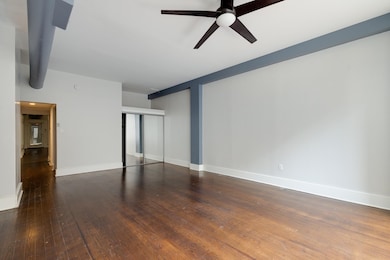 Unfurnished room with a ceiling fan, hardwood / wood-style floors, and baseboards