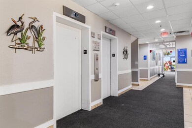 Hall featuring tile patterned floors, elevator, an