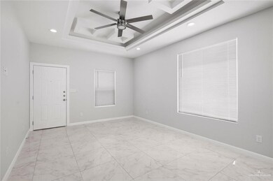 Spare room with ceiling fan and a tray ceiling