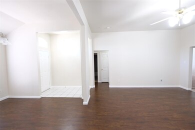 Empty room with ceiling fan and dark hardwood / wood-style floors