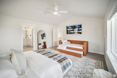 Bedroom featuring carpet floors, lofted ceiling, and a ceiling fan