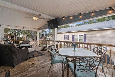 Deck with outdoor dining space, ceiling fan, and a