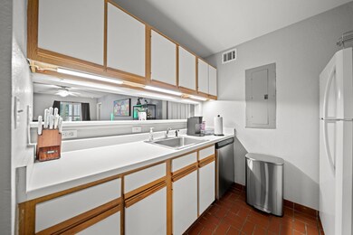 Kitchen with freestanding refrigerator, a sink, s