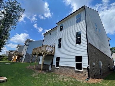 Back of house featuring a deck and a lawn