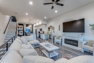 Living room with ceiling fan with notable chandeli