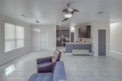 Tiled living room featuring ceiling fan and sink