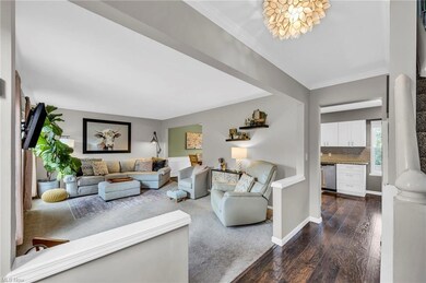 Hardwood floored living room featuring crown molding