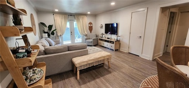 Living room with light wood-style flooring, french