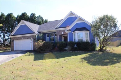 View of front facade with driveway, a front lawn, brick siding, and a garage