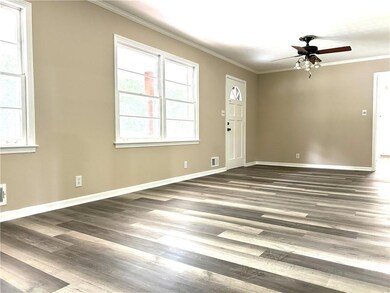 Empty room featuring crown molding, dark wood-type