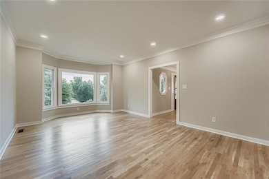 Spare room with ornamental molding, light wood finished floors, and recessed lighting