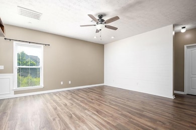 Unfurnished room featuring a ceiling fan, wood fin