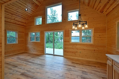 The main level offers in-floor heat, a cozy living room, one bedroom, a half bath, and patio doors to a peaceful deck with lake views.