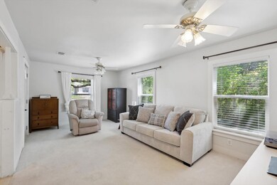Living room with light colored carpet, ceiling fan
