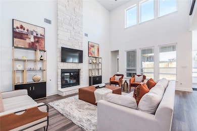 Living room with a towering ceiling, a stone fire