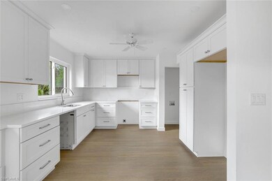Kitchen with a sink, a ceiling fan, wood finished floors, white cabinetry, and recessed lighting