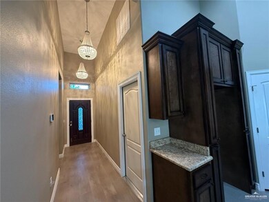 Doorway to outside featuring a chandelier, a high ceiling, and light wood-style flooring
