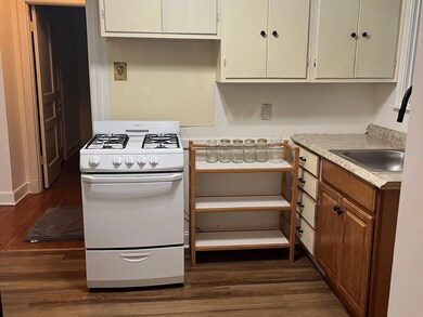 Kitchen with white gas range, dark hardwood / wood
