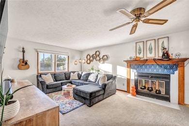 Living area with a tile fireplace, carpet, and ceiling​​‌​​​​‌​​‌‌​​​‌​​‌‌​​‌‌​‌​​​‌‌​​‌​​​​​‌ fan