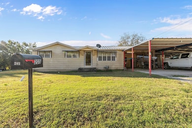 Single story home with a metal roof, a front lawn, a carport, and entry steps