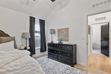 Bedroom with vaulted ceiling, baseboards, and a ceiling fan