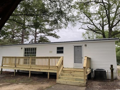 Back of property with central AC unit, a wooden de