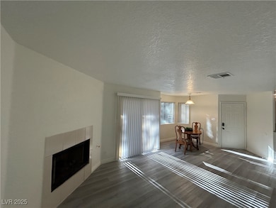 Living area with dark wood finished floors, a tile