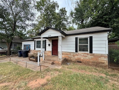 View of front of house featuring stone siding, roof with shingles, and crawl space