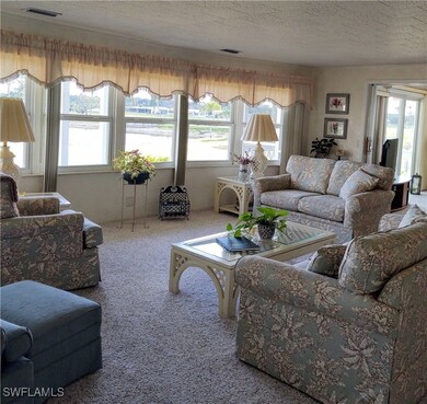 Living room with carpet, a textured ceiling, and a