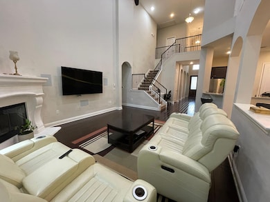 Living area with arched walkways, wood finished f