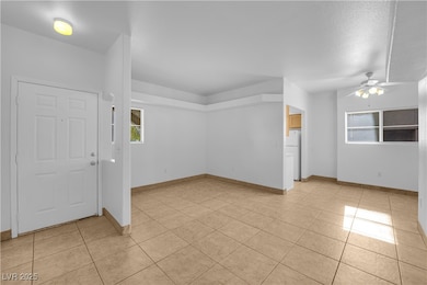 Entryway featuring light tile patterned flooring, a ceiling fan, and a textured ceiling