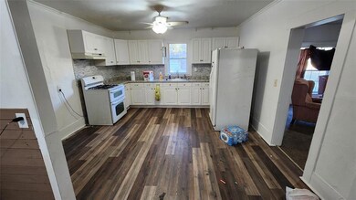 Kitchen featuring white cabinetry, ceiling fan, ba