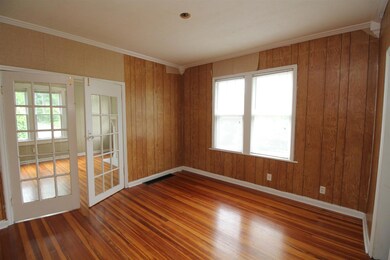 Dining room or office with french doors and lots of natural light from the large double window.