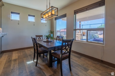 Dining room with dark wood-style flooring and a chandelier