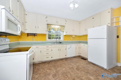 Vinyl flooring, wood cabinetry, matching appliances- microwave, electric range/oven, and refrigerator