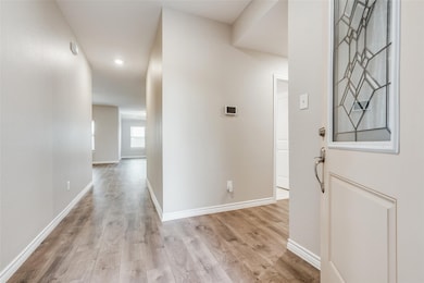Hall with light wood finished floors and baseboards