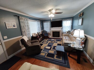 Living room with ceiling fan, a textured ceiling, 