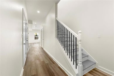 Staircase with wood finished floors and recessed lighting