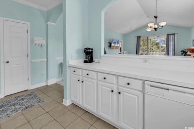 Kitchen with dishwasher, white cabinets, light countertops, light tile patterned flooring, and pendant lighting