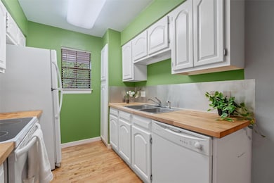 Kitchen featuring white appliances, a sink, light