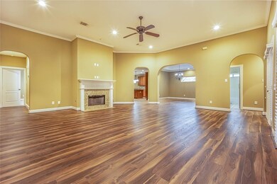 View from entrance of the huge family room, gleaming floors, gas fireplace, and ceiling fan.