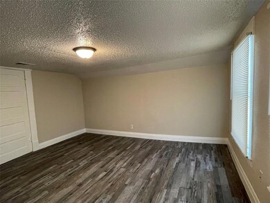 Empty room featuring dark vinyl finished floors, b