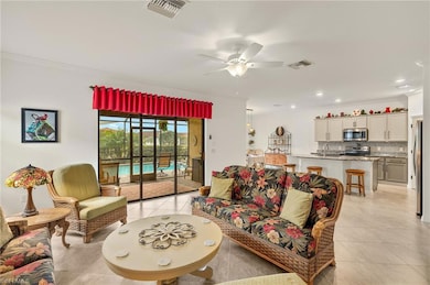 Living room featuring light tile floors, crown molding, ceiling fan and pool views