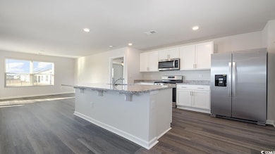Kitchen featuring white cabinetry, appliances with